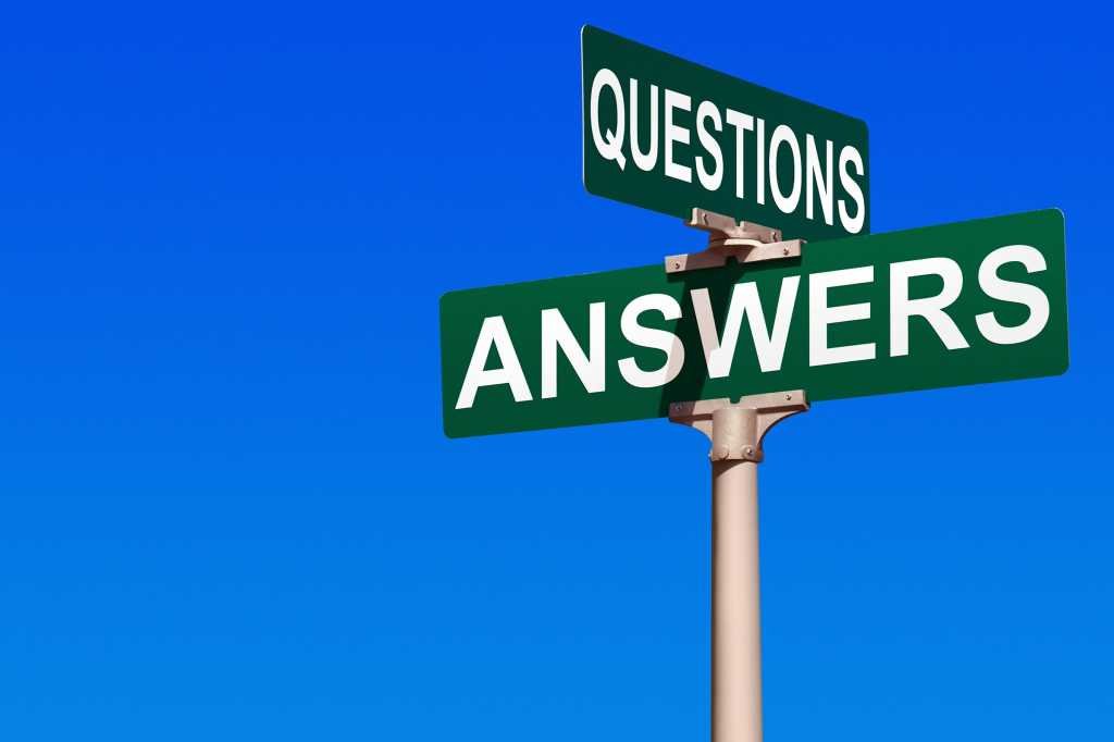 A signpost with white writing on green background reads Questions and Answers