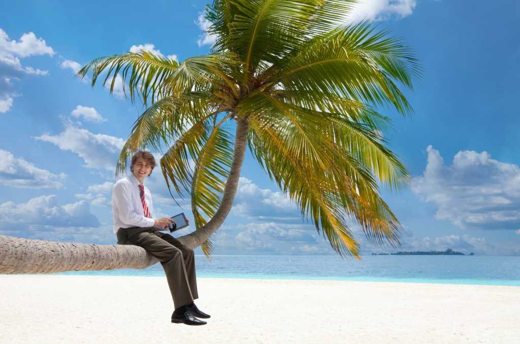 manager with tablet pc sitting on palm tree 137388439